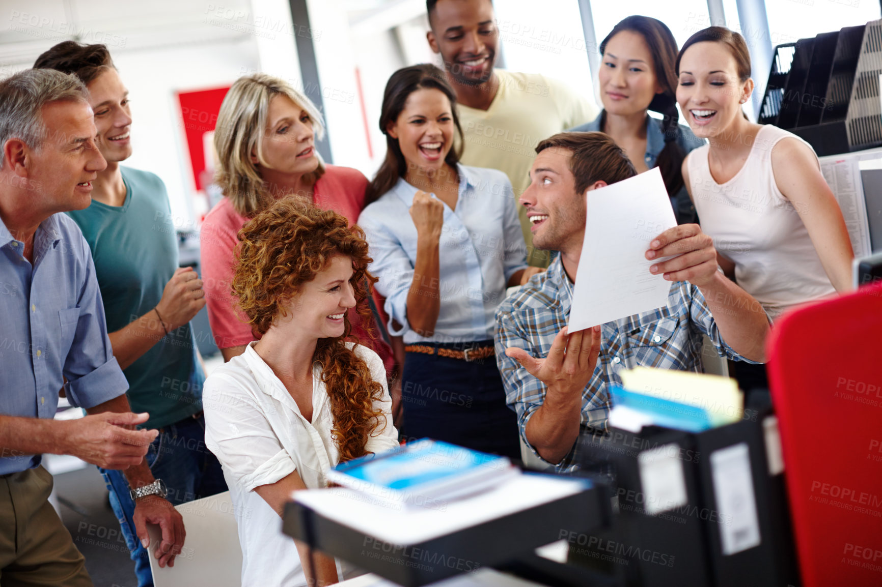 Buy stock photo Shot of a young man showing something to his colleagues in the office