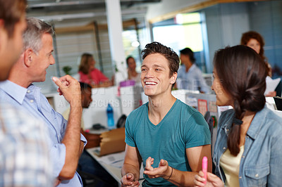 Buy stock photo Shot of a diverse group of coworkers enjoying a friendly conversation at the office
