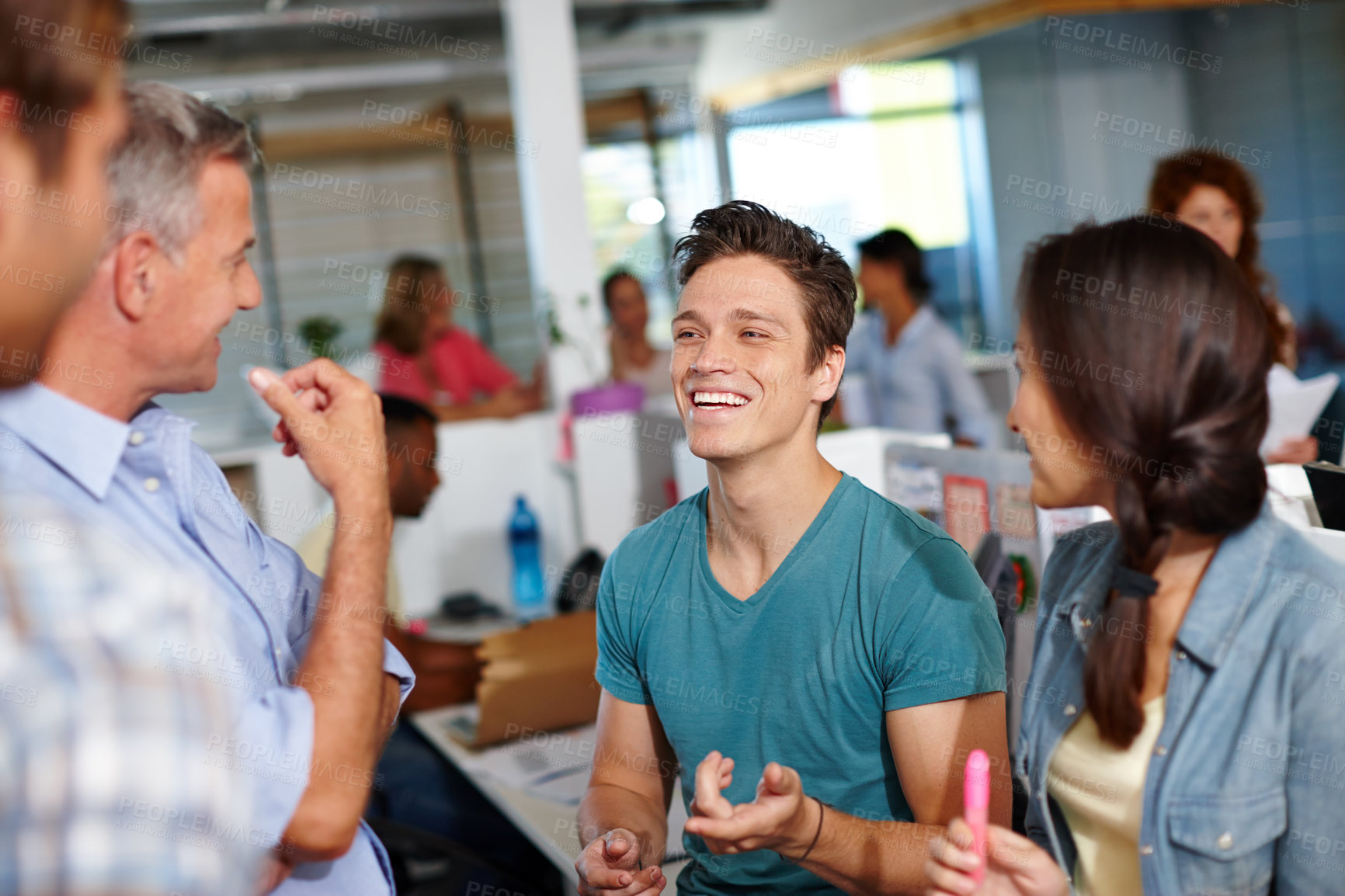 Buy stock photo Shot of a diverse group of coworkers enjoying a friendly conversation at the office