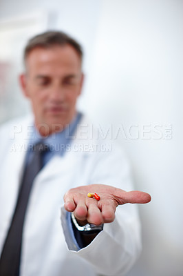 Buy stock photo Closeup shot of a doctor holding two capsules in his hand