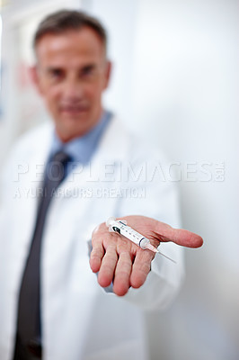 Buy stock photo Closeup shot of a doctor holding a syringe in his hand