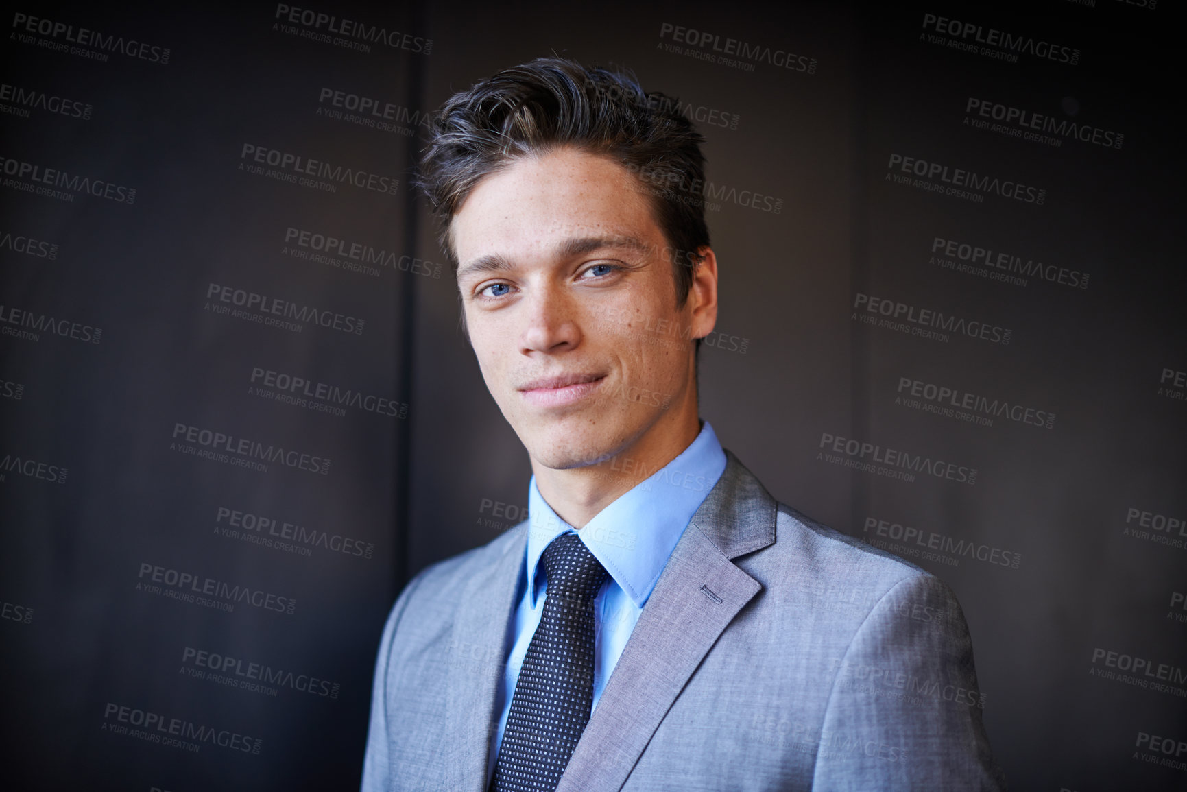 Buy stock photo Portrait of one handsome confident young caucasian businessman in a suit and tie standing against a dark background. Ambitious entrepreneur and dedicated corporate leader ready for success 