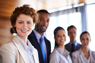 Buy stock photo Portrait of an attractive businesswoman with her colleagues standing behind her