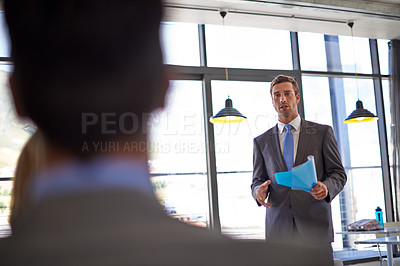 Buy stock photo Shot of a young businessman delivering a work presentation