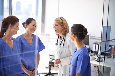 Buy stock photo Shot of a female doctor talking to a group of nurses at a hospital
