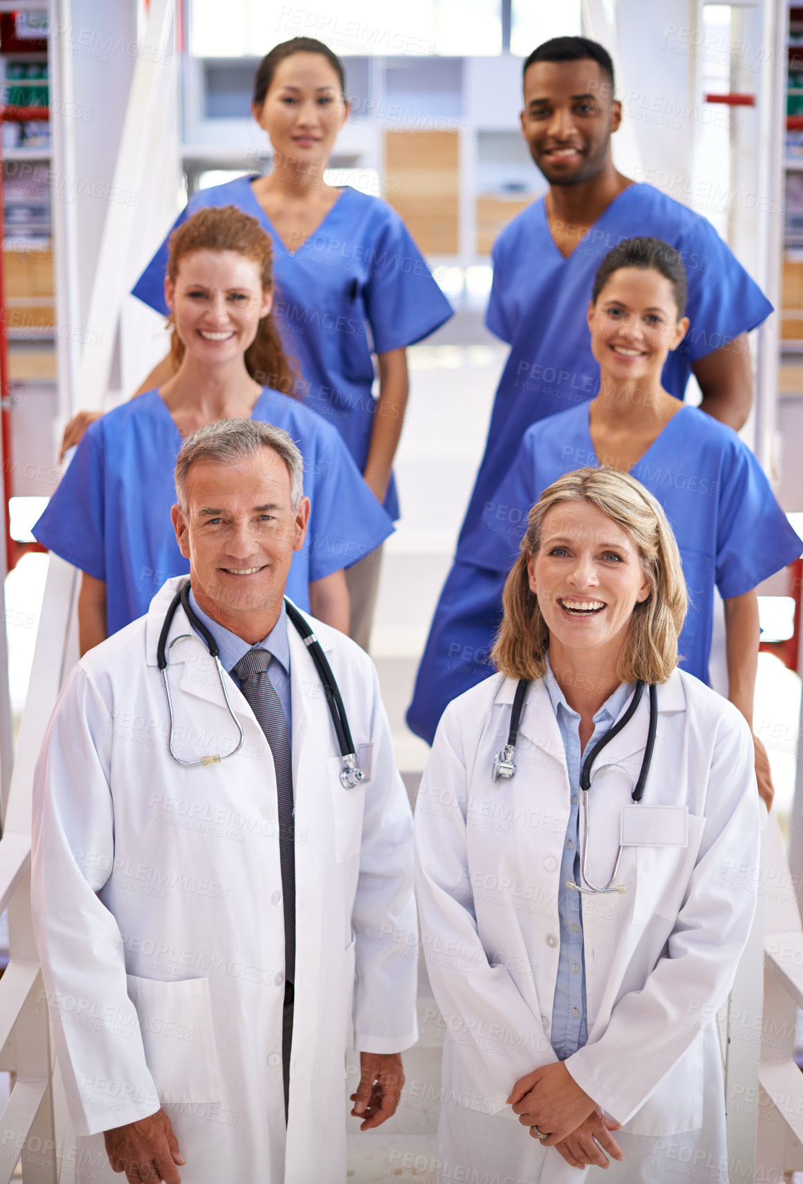 Buy stock photo Portrait of a diverse team of medical professionals standing on a staircase in a hospital