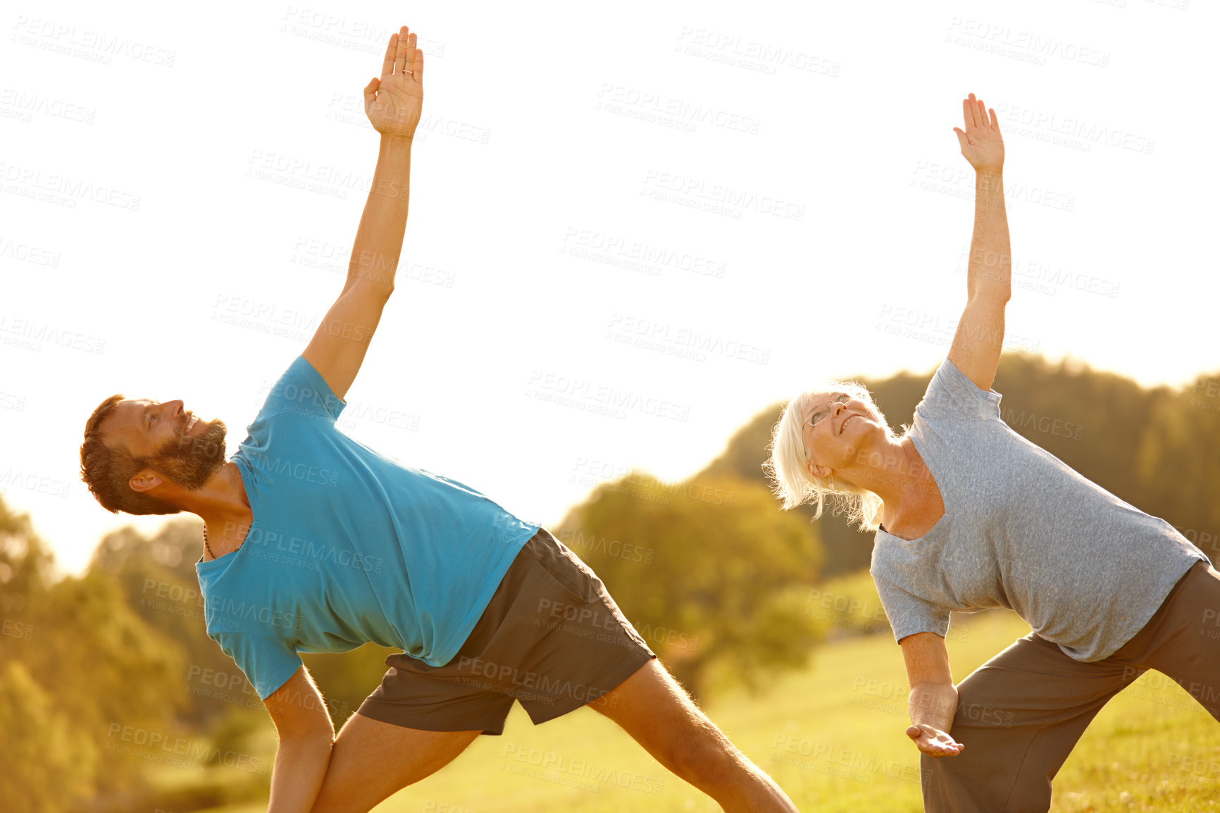 Buy stock photo Shot of a mature couple doing yoga together outdoors