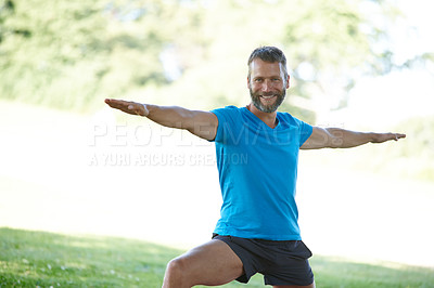 Buy stock photo Cropped shot of a handsome mature man doing yoga outdoors