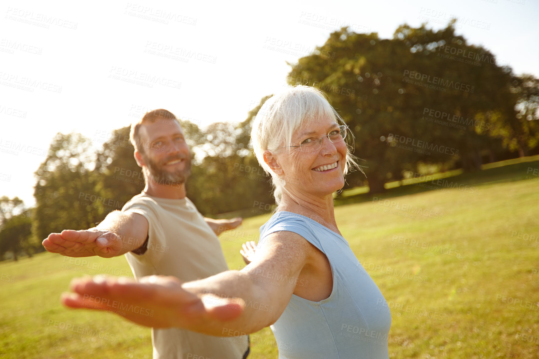 Buy stock photo Couple, stretching and portrait with yoga in park for exercise, balance and mobility in nature. Back, mature people or warrior pose on grass for arm workout, holistic wellness or fitness with pilates