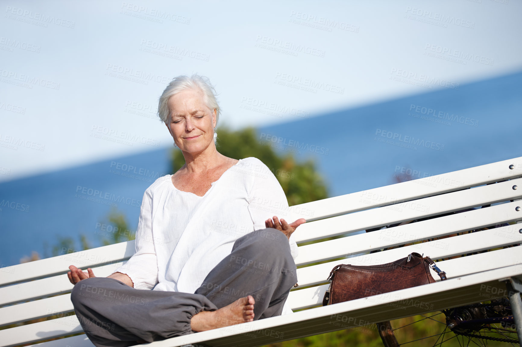 Buy stock photo Lotus, yoga and old woman on bench, meditation and calm with break, vacation and breathing. Pensioner, outdoor and senior lady with fitness, exercise and wellness with posture, balance and calming