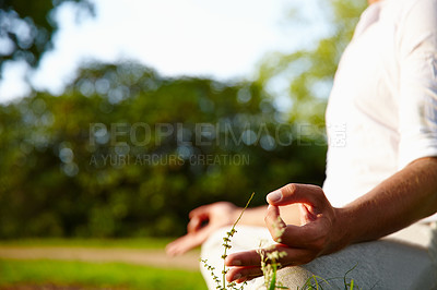 Buy stock photo Closeup of one man meditating in harmony with om finger gesture practising yoga on grass outdoors with copyspace. Calm and relaxed guy feeling zen praying quietly for stress relief and peace of mind 