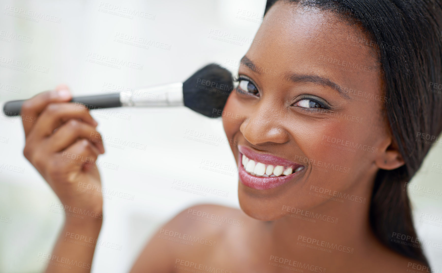 Buy stock photo Shot of a beautiful young woman applying blush with a makeup brush