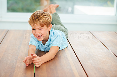 Buy stock photo Floor, child and happy with game in laughter, funny and joke with playing, growth and development. Boy, relax or smile in living room for silly, excited or home in care for safe fun in kindergarten