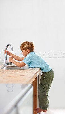 Buy stock photo Children, fantasy and a child in the kitchen sink, playing a game in his home as a plumber character. Kids, basin and counter with a curious young boy in a modern apartment for imaginary plumbing
