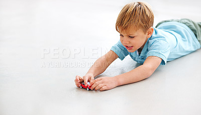 Buy stock photo Shot of an adorable little boy playing with a toy car