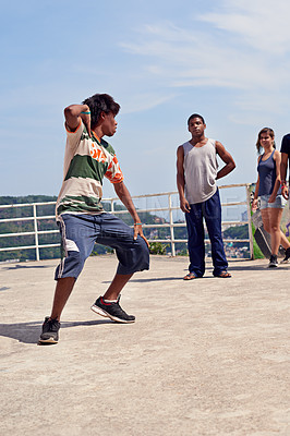Buy stock photo Shot of a group of young people watching a breakdancer in the streets