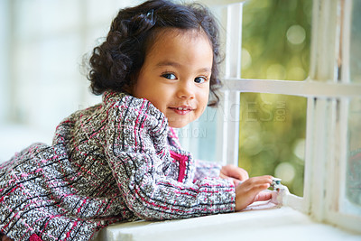 Buy stock photo Little girl, portrait and smile at window for relax, child development or happiness. Female toddler person, cute face and joyful play in home or learning growth, thinking or dress up clothes in room