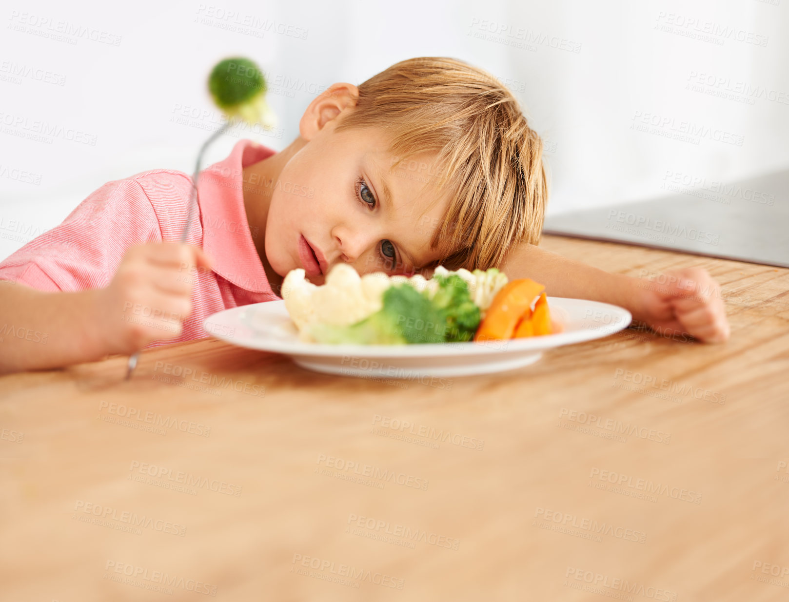 Buy stock photo Sad, hungry and a child with vegetables for dinner, unhappy and problem with food. Frustrated, diet and a little boy eating broccoli and carrots, disappointed with lunch and nutrition for youth