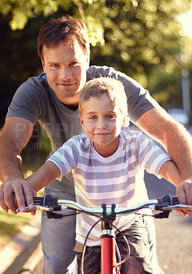 Buy stock photo Bicycle, ride and father help child with bike and learning on the road and parent support kid in vacation or holiday. Smile, development and dad together with son and teaching outdoor skills