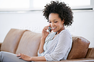 Buy stock photo Shot of an attractive woman talking on her cellphone while sitting on the sofa