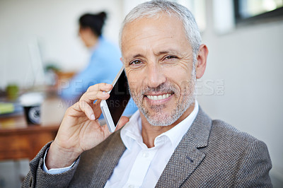 Buy stock photo Portrait of a mature businessman talking on a cellphone while sitting in an office