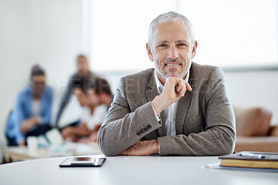 Buy stock photo Portrait of a mature businessman sitting at a table in an office