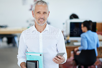 Buy stock photo Portrait of a mature businessman using a cellphone while standing in an office