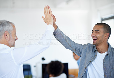 Buy stock photo Shot of two business colleagues high-fiving in an office