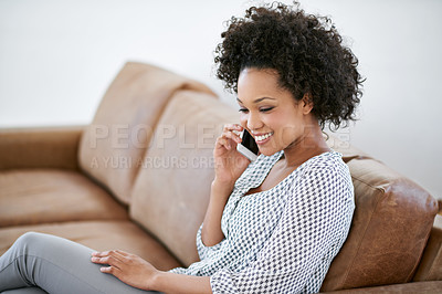 Buy stock photo Shot of an attractive woman talking on her cellphone while sitting on the sofa at home