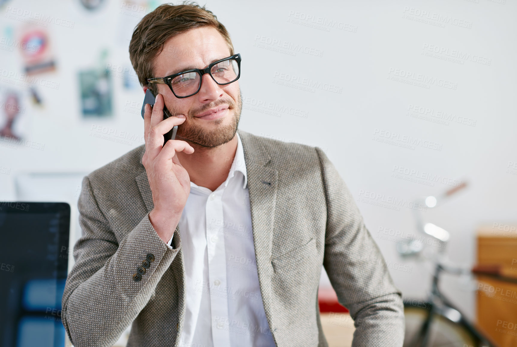 Buy stock photo Shot of a handsome businessman talking on his cellphone in the office.The commercial designs displayed  represent a simulation of a real product and have been changed or altered enough by our team of retouching and design specialists so that they don't have copyright infringements
