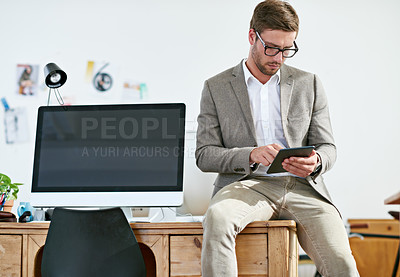 Buy stock photo Shot of a casually-dressed young man sending a text message while at work. The commercial designs displayed  represent a simulation of a real product and have been changed or altered enough by our team of retouching and design specialists so that they don't have copyright infringements