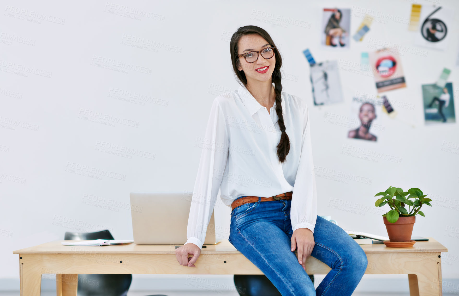 Buy stock photo Shot of a beautiful young woman working in a modern office. The commercial designs displayed represent a simulation of a real product and have been changed or altered enough by our team of retouching and design specialists so that they don't have copyright infringements