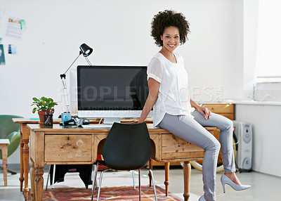 Buy stock photo Full length portrait of an attractive young businesswoman sitting on her desk at work. The commercial designs displayed represent a simulation of a real product and have been changed or altered enough by our team of retouching and design specialists so that they don't have any copyright infringements