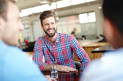 Buy stock photo Shot of a young male designer in a meeting with his colleagues