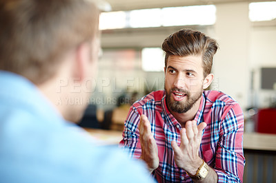 Buy stock photo Shot of two colleagues discussing work in the office