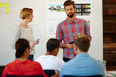 Buy stock photo Shot of a group of young designers having a brainstorming meeting at a whiteboard