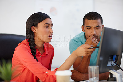 Buy stock photo Shot of two young designers working together at a computer
