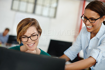 Buy stock photo Shot of two female designers working together at a computer
