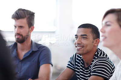 Buy stock photo Shot of a young business professional in a meeting with his colleagues
