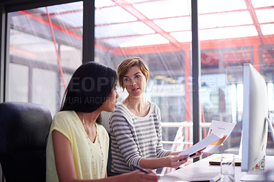 Buy stock photo Shot of two colleagues working together at a desk