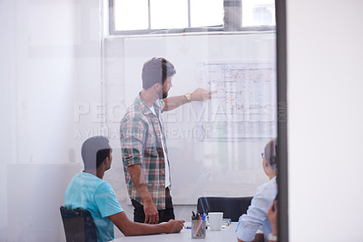 Buy stock photo Shot of a handsome young man working in his office
