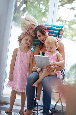 Buy stock photo Relax, lesbian parents and tablet for children, adoption and happiness with family home, bonding or love. Female people, foster mom and tech in house, lounge or apartment on weekend for lgbt marriage