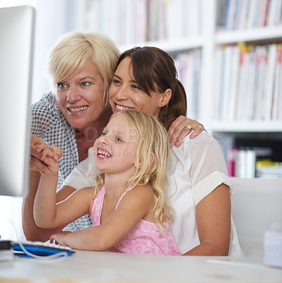 Buy stock photo Computer, happy family and lesbian couple with child in home for learning, teaching or adoption of girl. Kid, mothers or gay parents with technology for playing funny game, meme and women laugh on pc