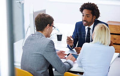 Buy stock photo Shot of a businessman explaining something to his colleagues