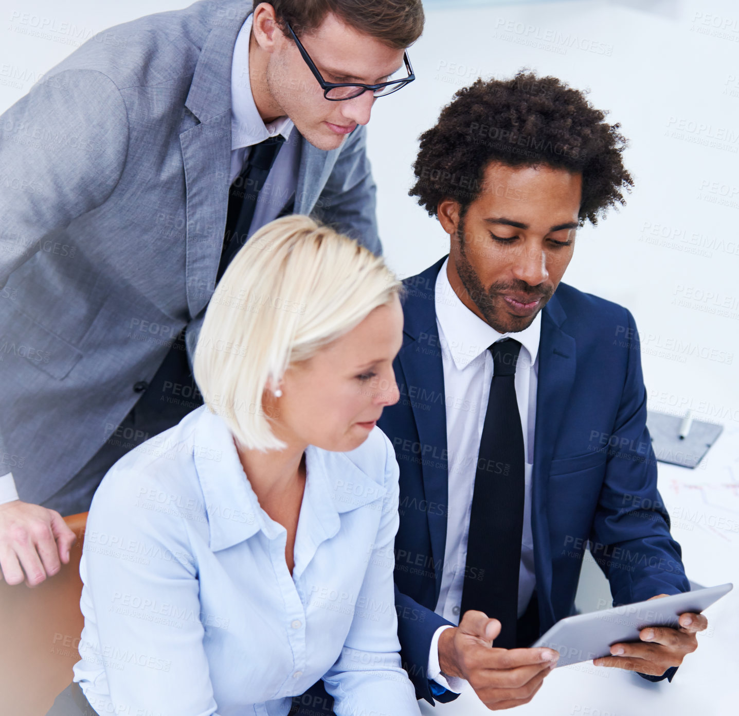 Buy stock photo Shot of staff memers looking at a digital tablet together