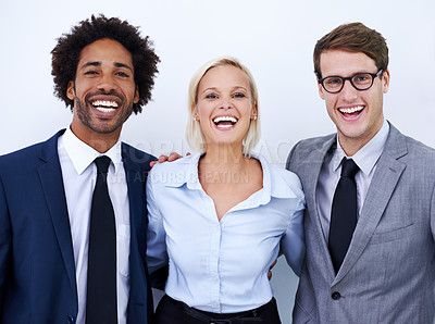 Buy stock photo Portrait of three happy colleagues smiling confidently at the camera against a white background
