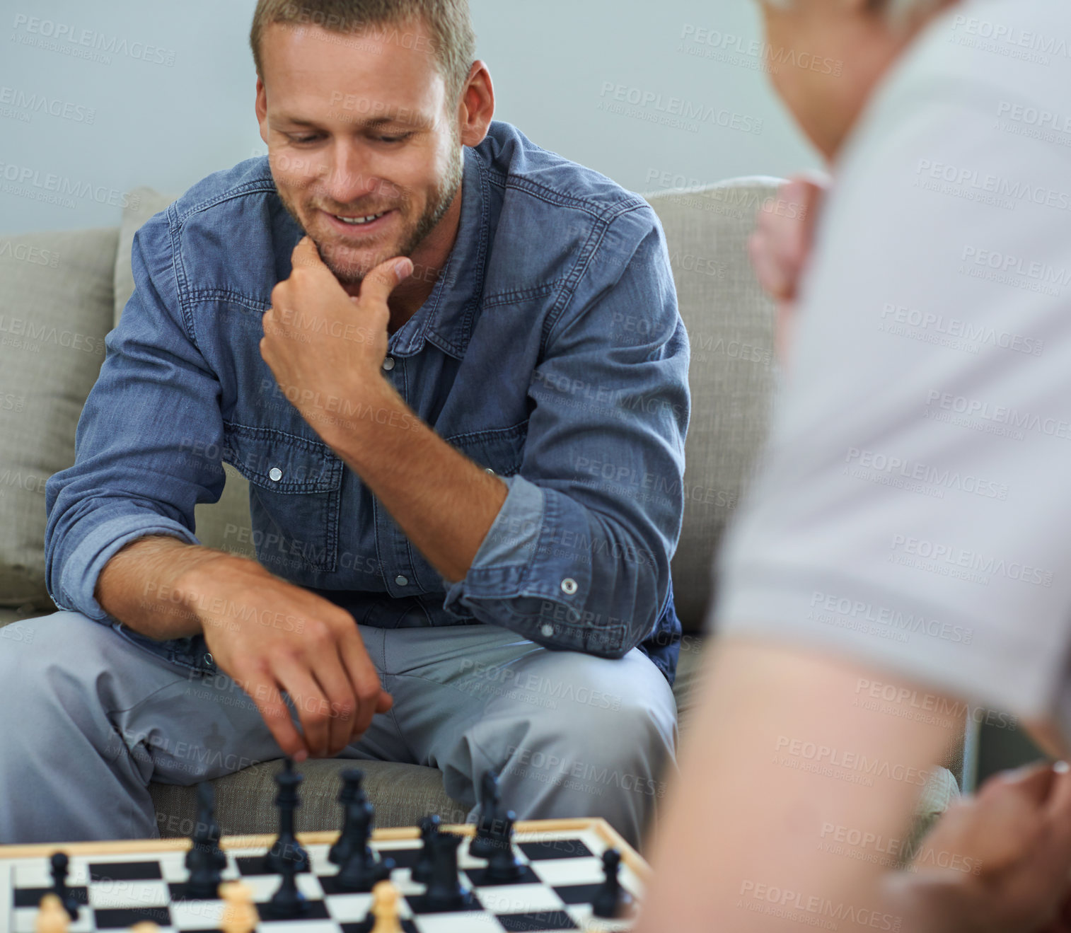 Buy stock photo Smile, man or thinking of chess move in home for games or contest for strategy and problem solving. Happy, friends or board for challenge, checkmate or learning mental skills for cognitive function