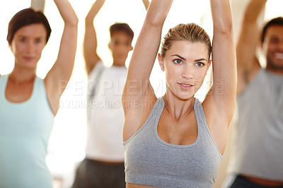 Buy stock photo Cropped shot of a beautiful young woman stretching in yoga class