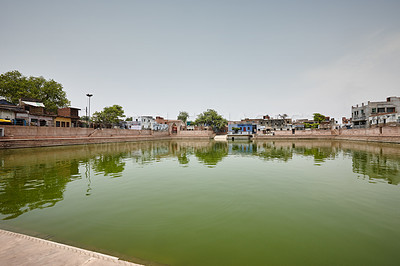 Buy stock photo Sacred pool, nature and water with religion, belief and buildings in India, worship and travel. Empty, spiritual and outdoor with cleansing, Krishna and myth with culture, tradition and tourism