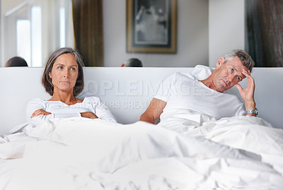 Buy stock photo Shot of a mature married couple upset with each other in the bedroom